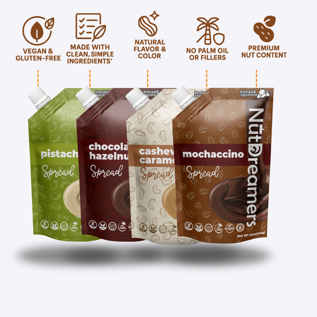 Four packages of Nut Dreamers Spread with different flavors on a white background.