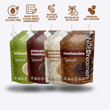 Four packages of Nut Dreamers Spread with different flavors on a white background.
